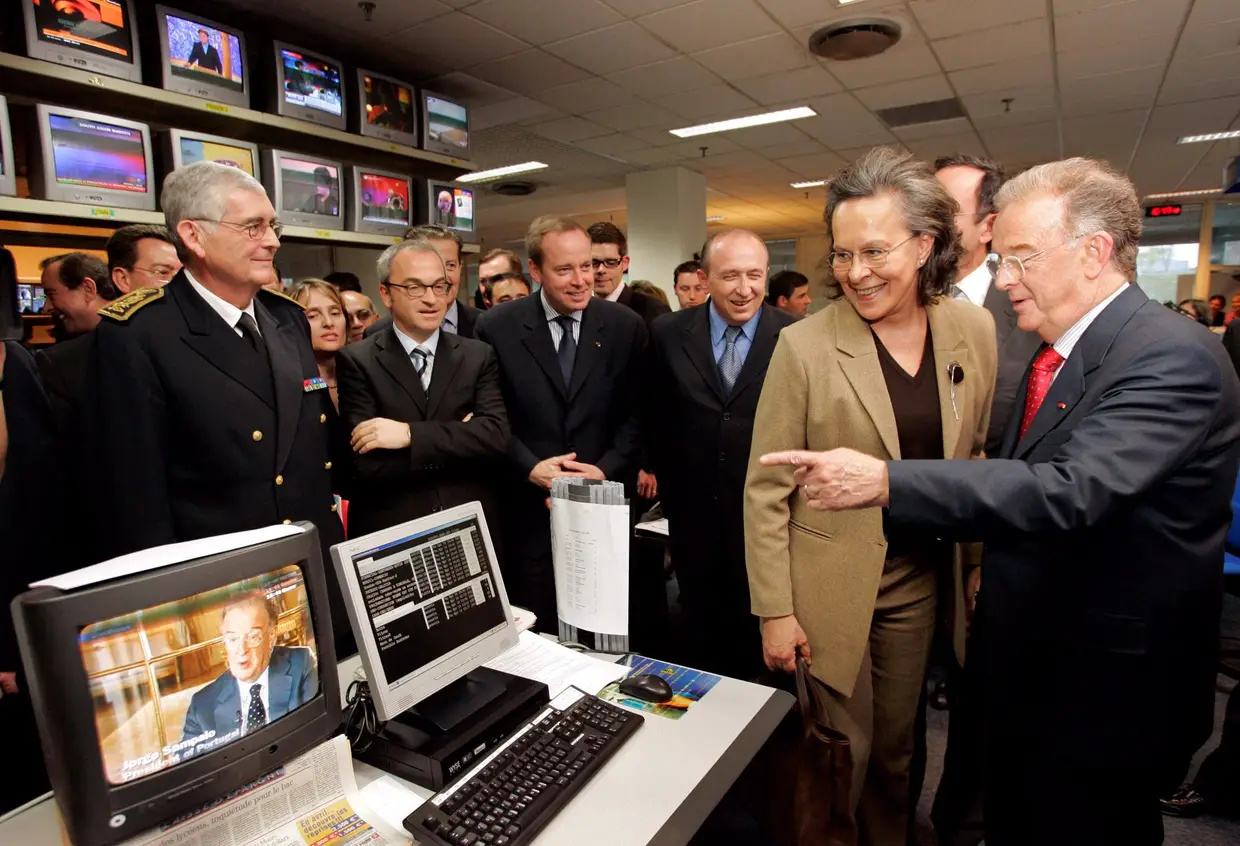 14 abril 2005 - O Presidente da República, Jorge Sampaio, e a primeira-dama, Maria José Rita, observam uma televisão onde estava a ser exibida a imagem do chefe de Estado português, durante uma visita à sede da Euronews, em Ecully, França.