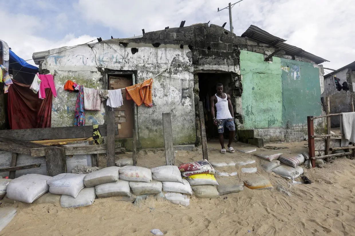 Sacos de areia para tentar proteger uma casa contra a erosão do mar na favela costeira de West Point em Monróvia, Libéria.