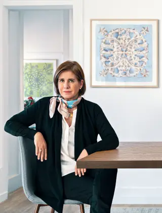 Fernanda Lamelas no atelier e show-room em Lisboa, com o lenço ‘Grémio Literário’ ao pescoço. Na parede, em primeiro plano, à direita, o modelo ‘Carmo’ e ao fundo, à esquerda, o modelo ‘Filigrana’