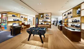 A loja renovada em Lisboa destaca a coleção masculina no piso térreo, com uma mesa de matraquilhos e uma prancha de surf