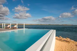 Com uma ‘piscina infinita’ (que se funde com o horizonte) e uma língua de areia com espreguiçadeiras, o Grand Beach Club está instalado numa antiga base militar