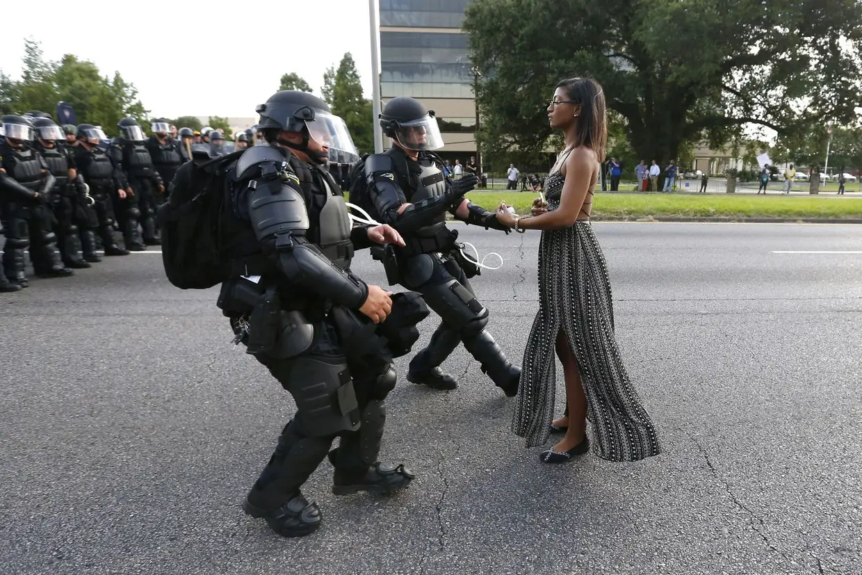 Primeiro na Categoria Temas Contemporâneo, da autoria do americano Jonathan Bachman. A ativista Leshia Evans enfrenta sozinha e sem resistência a polícia durante os protestos contra a brutalidade policial em Baton Rouge, no Louisiana, em julho de 2016.