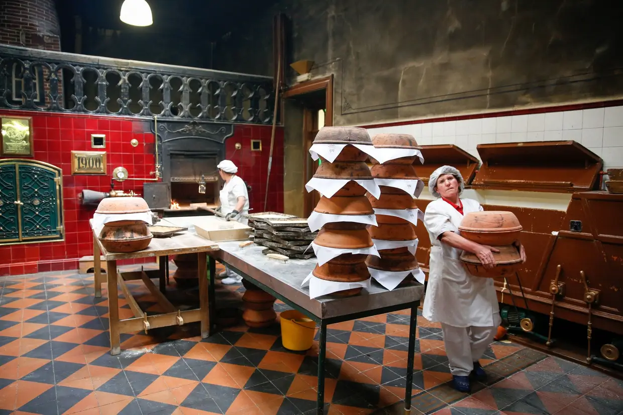 Enquanto a massa fica no ponto, envolvem-se as formas de barro em papel que hão de entrar no forno a lenha