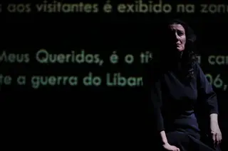 A atriz Antónia Terrinha está sozinha em palco, rodeada de vozes