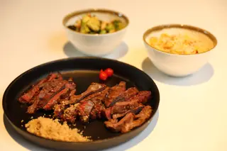 Cachaço de porco na brasa com molho chimichurri e arroz Biro-Biro é um dos pratos do Jacaré, do chefe José Avillez