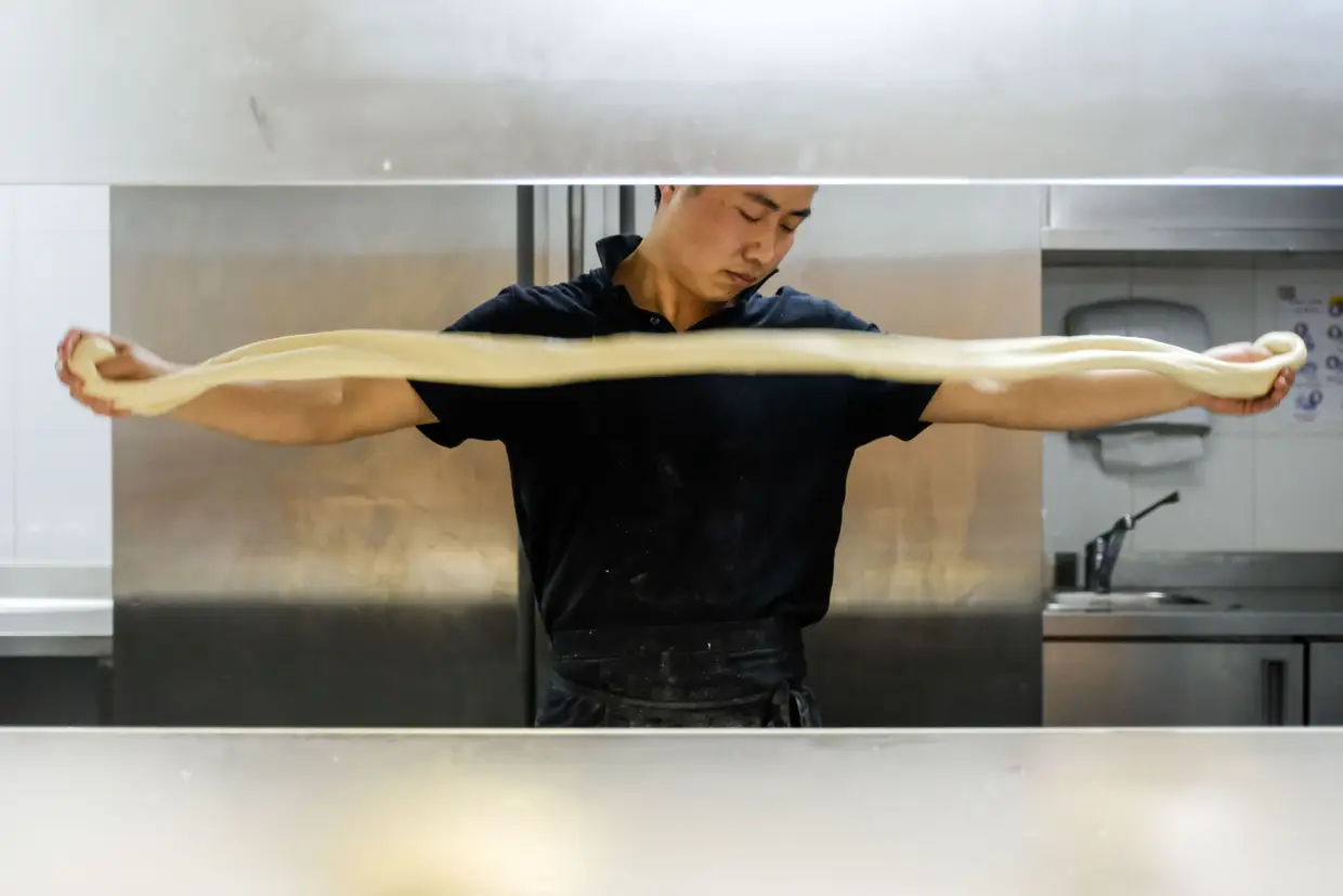 No Happy Noodles, em Lisboa, assim que o cliente pede um dos cinco ramen da lista, há que pegar na massa, batê-la e esticá-la com as mãos, até esta se transformar em fios sem fim. Veja o passo a passo