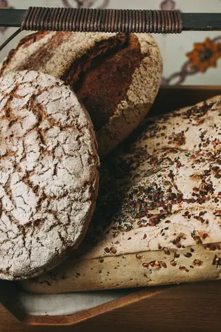 Chegam à mesa três variedades de pão de centeio, de trigo-sarraceno e sem glúten
