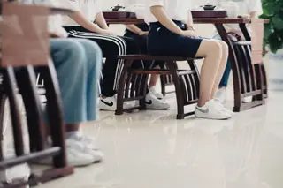 Alunas chinesas a aprender a maneira correta de se sentarem numa cadeira