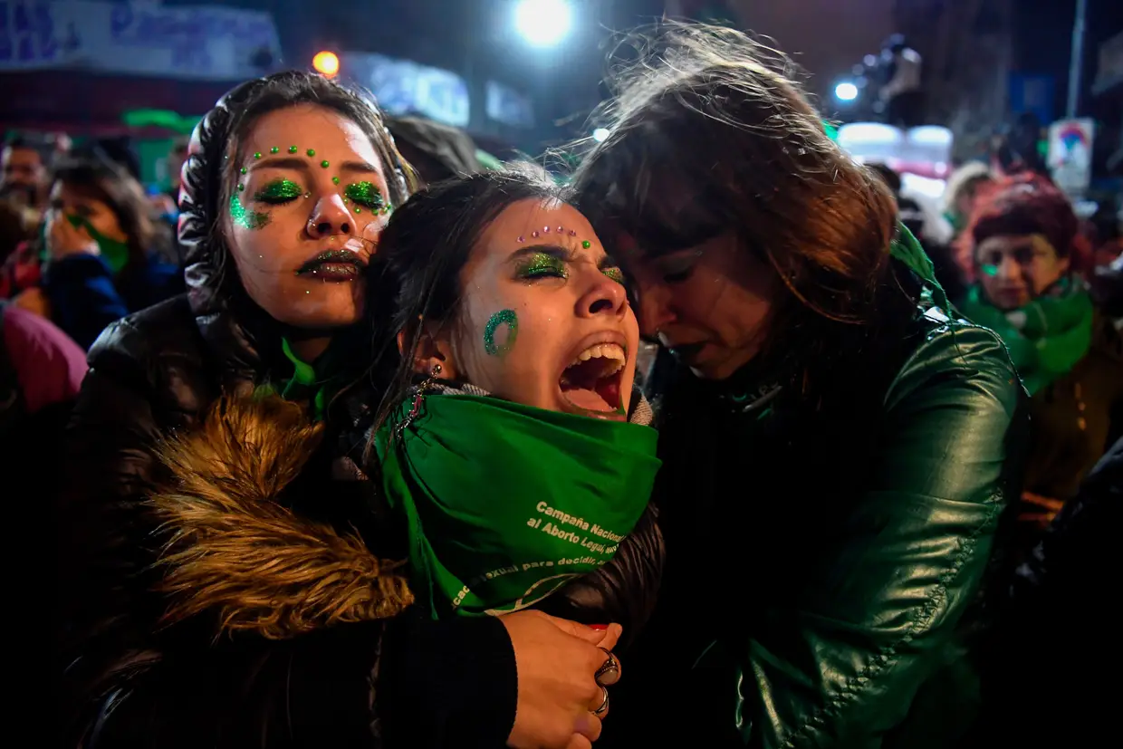 Ativistas a favor da legalização do aborto se consolam mutuamente fora do Congresso Nacional em Buenos Aires, em 9 de agosto de 2018, depois d os senadores rejeitarem o projeto de lei para legalizar o aborto