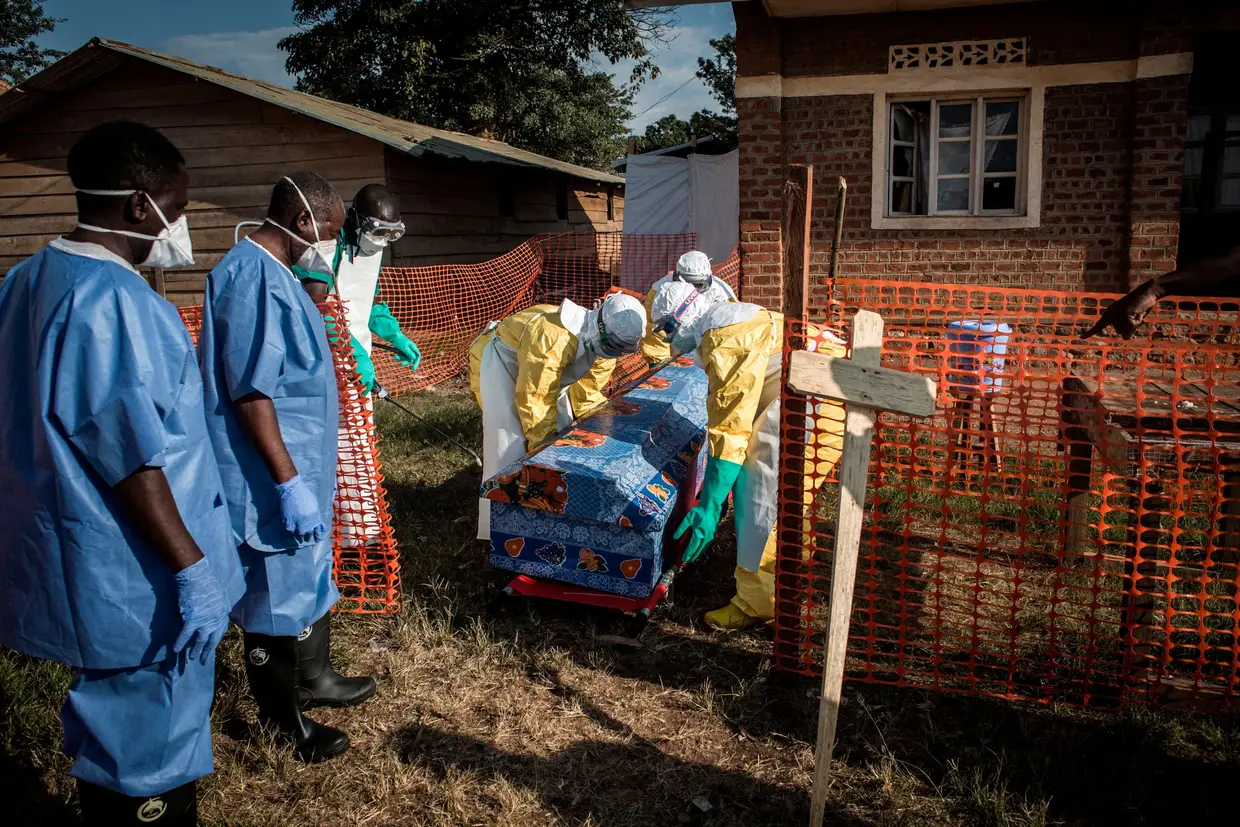 Equipes médicas desinfetam o caixão de um paciente Ebola não confirmado falecido dentro de um Centro de Tratamento de Ebola administrado pela Aliança para Ação Médica Internacional (ALIMA) em 13 de agosto de 2018, no Beni, no Congo