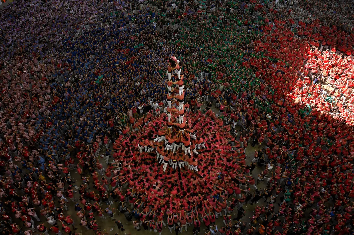Membros da equipa de torre humana "Colla Vella dels Xiquets de Valls" formam um "castell", vencendo a competição em Tarragona em 7 de outubro de 2018. - Estas competições de torres humanas são tradicionais em festivais na Catalunha