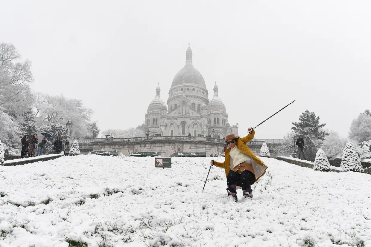 Uma mulher faz esqui na colina de Montmartre coberta de neve em frente à Basílica do Sagrado Coração (Basilique du Sacre-Cur), a de fevereiro de 2018, em Paris