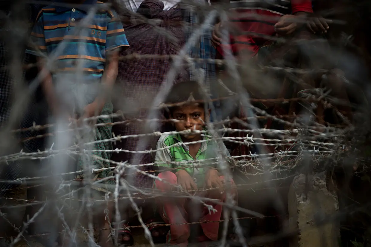 Refugiados Rohingya reúnem-se na "terra de ninguém" cercados por cercas de arame farpado no distrito de Maungdaw, estado de Rakhine, delimitado pelo Bangladesh em 25 de abril de 2018. O governo de Mianmar anunciou em 15 de abril a repatriação Rohingya de cerca de 700.000 refugiados que fugiram de uma campanha militar brutal