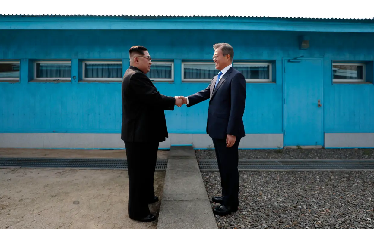 O líder da Coréia do Norte Kim Jong Un aperta a mão do Presidente da Coreia do Sul, Moon Jae-in na Linha de Demarcação Militar que divide seus países antes da cimeira histórica na aldeia de Panmunjom em 27 de abril de 2018