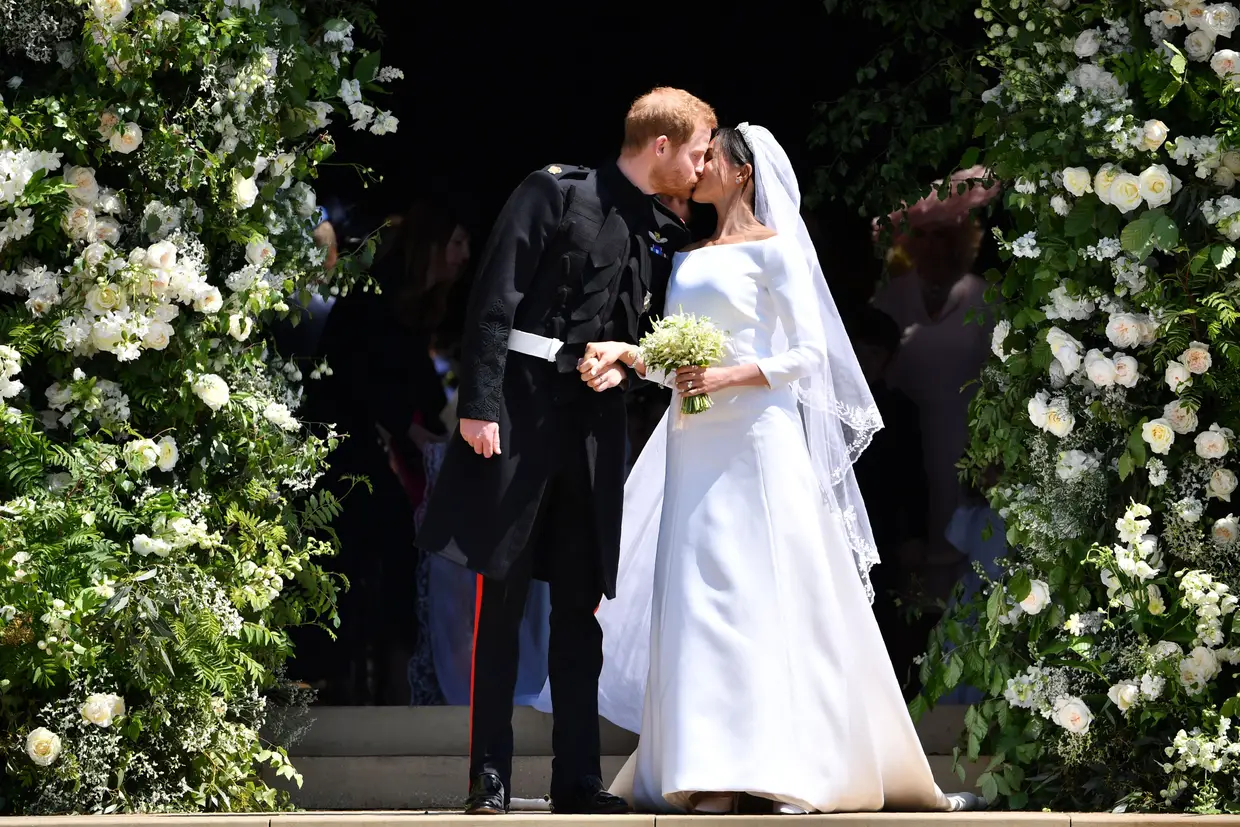 O príncipe Harry da Grã-Bretanha, Duque de Sussex, beija sua esposa Meghan, duquesa de Sussex quando saem da Porta Oeste da Capela de São Jorge, no Castelo de Windsor, em Windsor, em 19 de maio de 2018 após a cerimónia de casamento