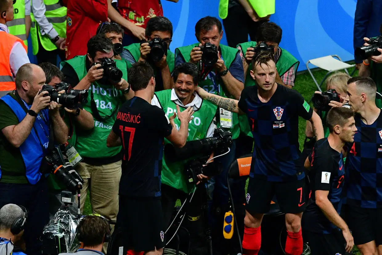 Mario Mandzukic, da Croácia, cumprimenta o fotógrafo da AFP, Yuri Cortez depois de o abalrroar juntamente com colegas de equipa enquanto festejava o segundo golo da Croácia contra a Inglaterra, no Mundial da Rússia, no Estádio Luzhniki, em Moscovo. Julho de 2018