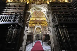 Forradas a folha de ouro e decoradas com motivos chineses, as estantes da Biblioteca Joanina guardam um acervo de cerca de 60 mil livros, com inúmeras relíquias desde o século XVI ao XVIII