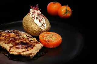 No menu de almoço de sexta-feira sugere-se entrecôte grelhado, batata recheada com queijo creme de alho e ervas, e tomate assado