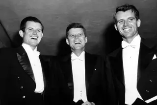 Os Kennedy, glória e drama O patriarca Joseph (Joe) Patrick Kennedy foi o primeiro presidente do organismo americano de regulação de valores imobiliários, após o crash de 1929, e embaixador dos EUA no Reino Unido. Empresário milionário, teve nove filhos, de que se destacaram estes três políticos. Ted (falecido em 2018), o “Leão do Senado”, foi um membro histórico daquele órgão, para o qual foi sucessivamente eleito. John Fitzgerald (JFK, ao centro) foi Presidente dos Estados Unidos da América. Robert (Bobby), anteriormente eleito senador, foi procurador-geral, durante a Administração do irmão e, posteriormente, candidato presidencial (assassinado, como JFK).