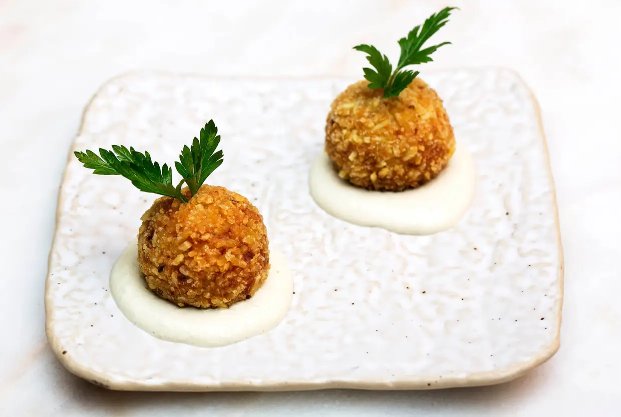 Croquetes de bacalhau à Brás, preparado com bacalhau da Islândia, salsa, cebola, batata palha e maionese de azeitona verde