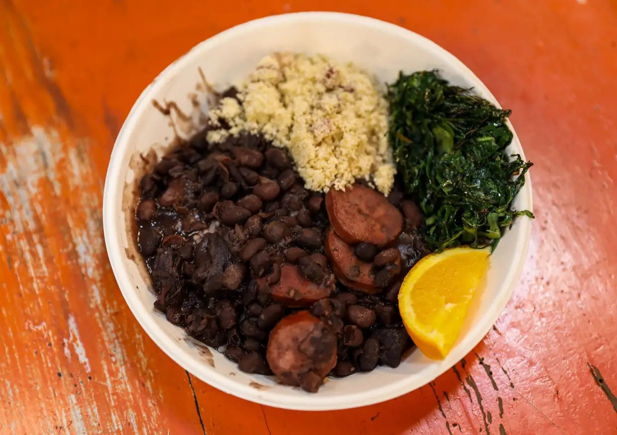 A feijoada à brasileira de Rodrigo Guimerà leva feijão-preto, carne seca, salsicha e costela fumada, salpicão, e acompanha com farofa, couve picada e refogada em alho