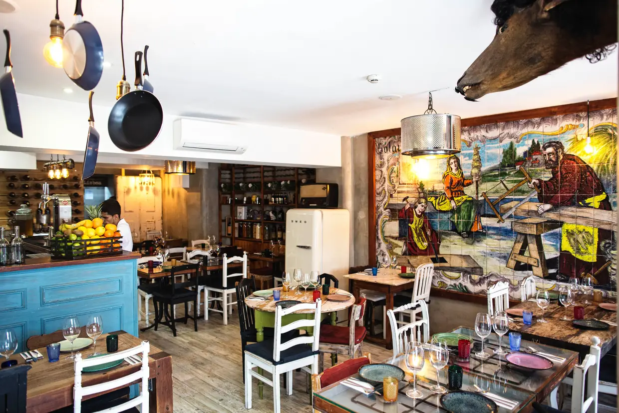 No restaurante Sr. Lisboa saltam à vista os candeeiros adornados com frigideiras e colheres de pau e o mural herdado da anterior tasca
