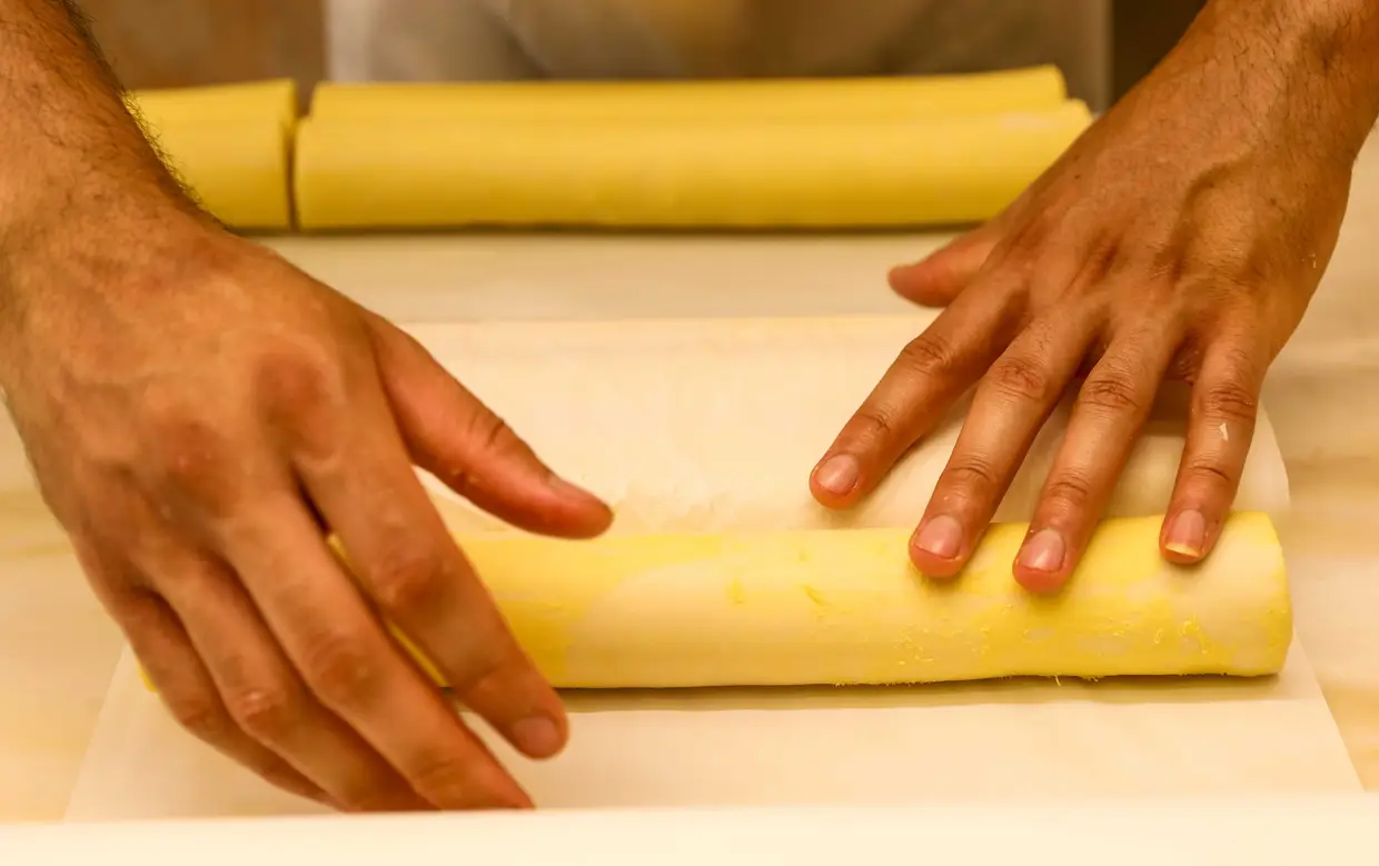Cada pedaço de massa folhada é envolto em papel vegetal para não secar