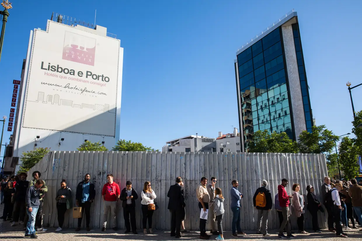 Espaço Registos – Fontes Pereira de Melo Cerca de 200 pessoas aguardam a abertura do Espaço Registos, na av. Fontes Pereira de Melo, no centro de Lisboa. Ali funcionam as conservatórias dos registos civis e comerciais, além dos balcões de divórcios com partilha de bens, de heranças e o casa pronta. A fila dá a volta à esquina com a av. António Augusto de Aguiar, uns bons metros mais abaixo. Os últimos arriscam-se a já não conseguir senha para o documento de que precisam. Em poucos minutos, as do Cartão de Cidadão e do Passaporte atingem o limite. Todos os dias, é uma corrida a passo de caracol - ainda mais lenta do que o para-arranca do trânsito ali ao lado, em hora de ponta. Para evitar a espera, o Instituto Nacional de Registos aconselha a marcar atentimento via internet. Experimentámos: em Lisboa, a próxima vaga no calendário é em outubro (em todo o distrito, Alenquer é o mais rápido que se arranja, no final de agosto); no Porto, consegue-se em agosto (em Santo Tirso é possível antecipar alguns dias). Bragança, Chaves, Guarda, Portalegre e ilhas são os únicos locais onde se marca de um dia para o outro.