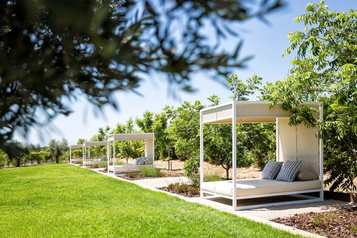 No relvado, frente ao terraço, as 'daybeds' convidam ao descanso