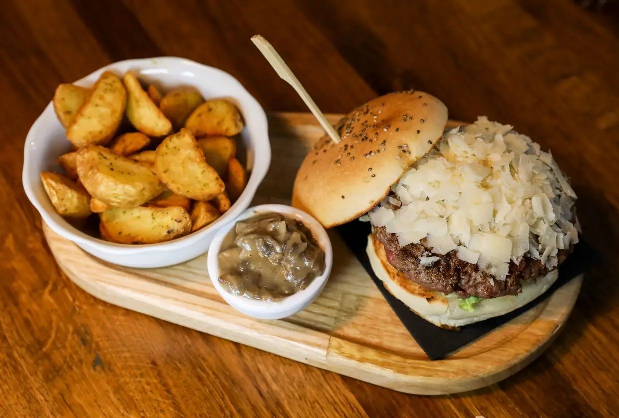 Hambúrguer de carne maturada com lascas de queijo parmesão e molho de cogumelos