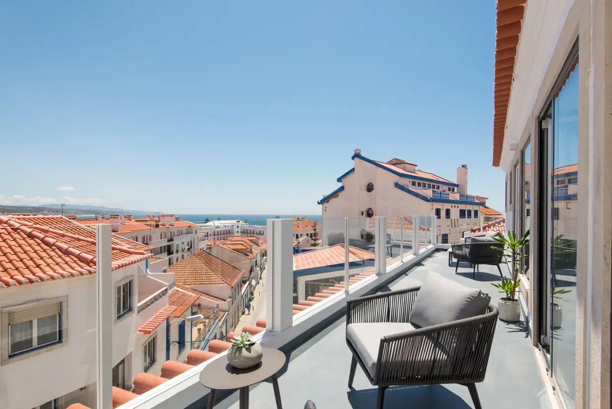 Os telhados do casario típico da vila e o mar azulíssimo lá ao fundo – a vista que encanta quem repousa numa das varandas dos pisos mais altos