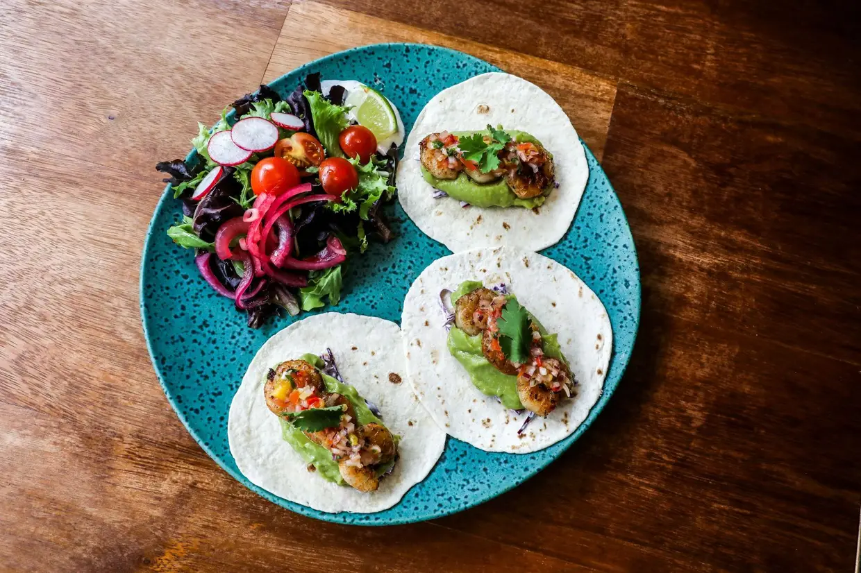 Tacos de camarão grelhados com abacate, manga e couve-roxa