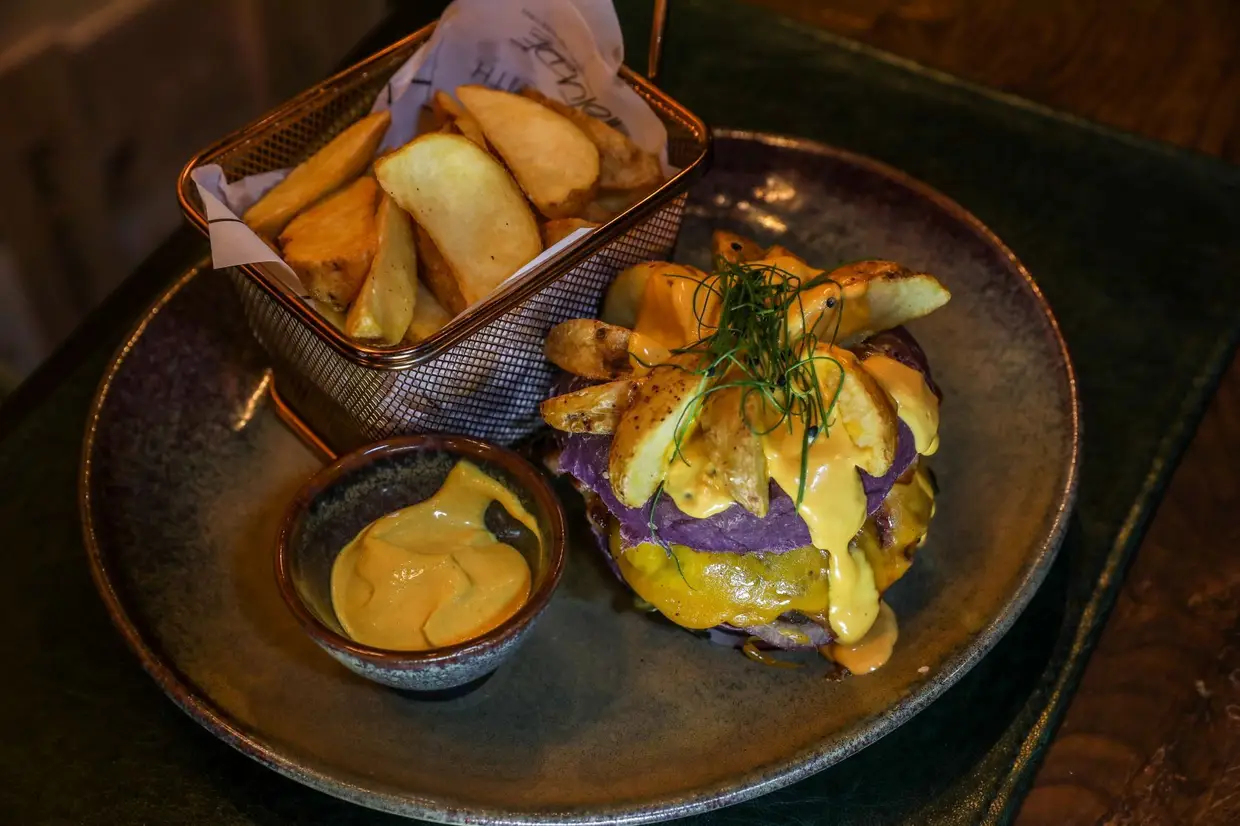 Os pães de hambúrguer, de diferentes cores, são um dos atrativos: neste caso, o Sidney, é feito com couve roxa e inclui carne de novilho, queijo cheddar, cebola roxa, sonnomono, bacon e molho cheddar
