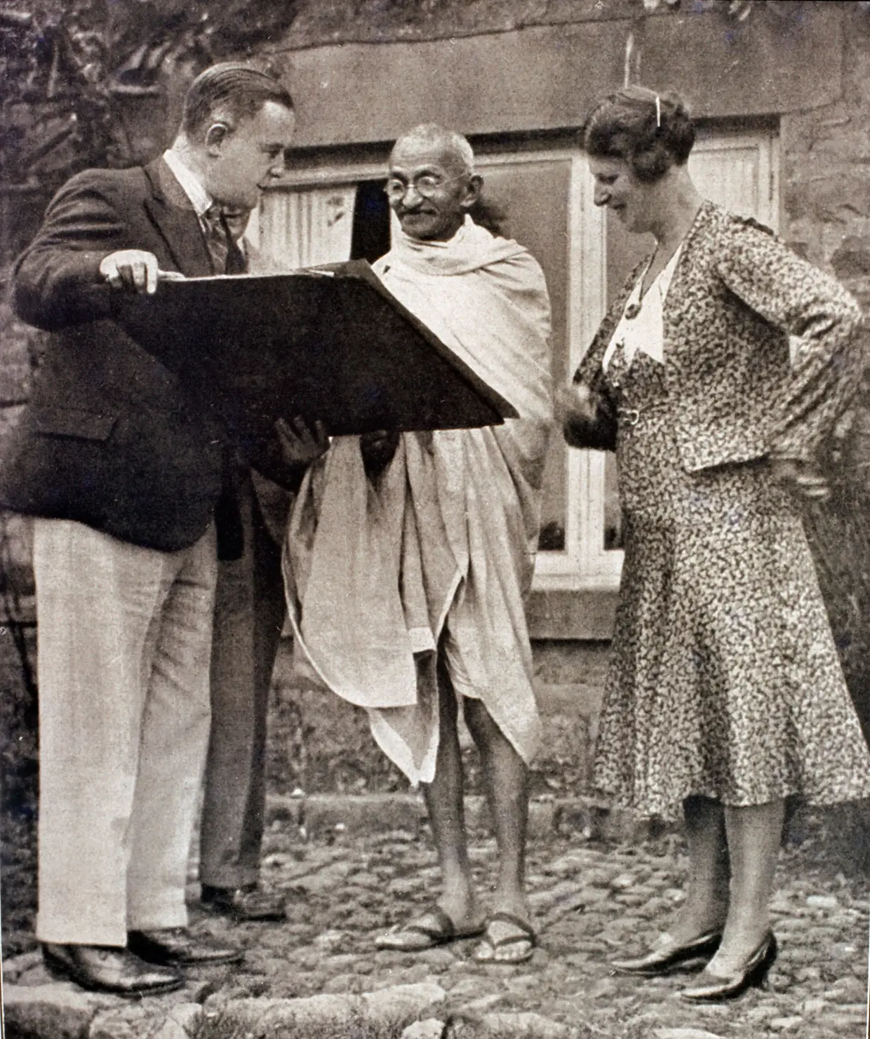 Imagem do líder pacifista indiano Mahatma Gandhi a dar um autógrafo em Inglaterra, retirada de uma revista italiana de 1931