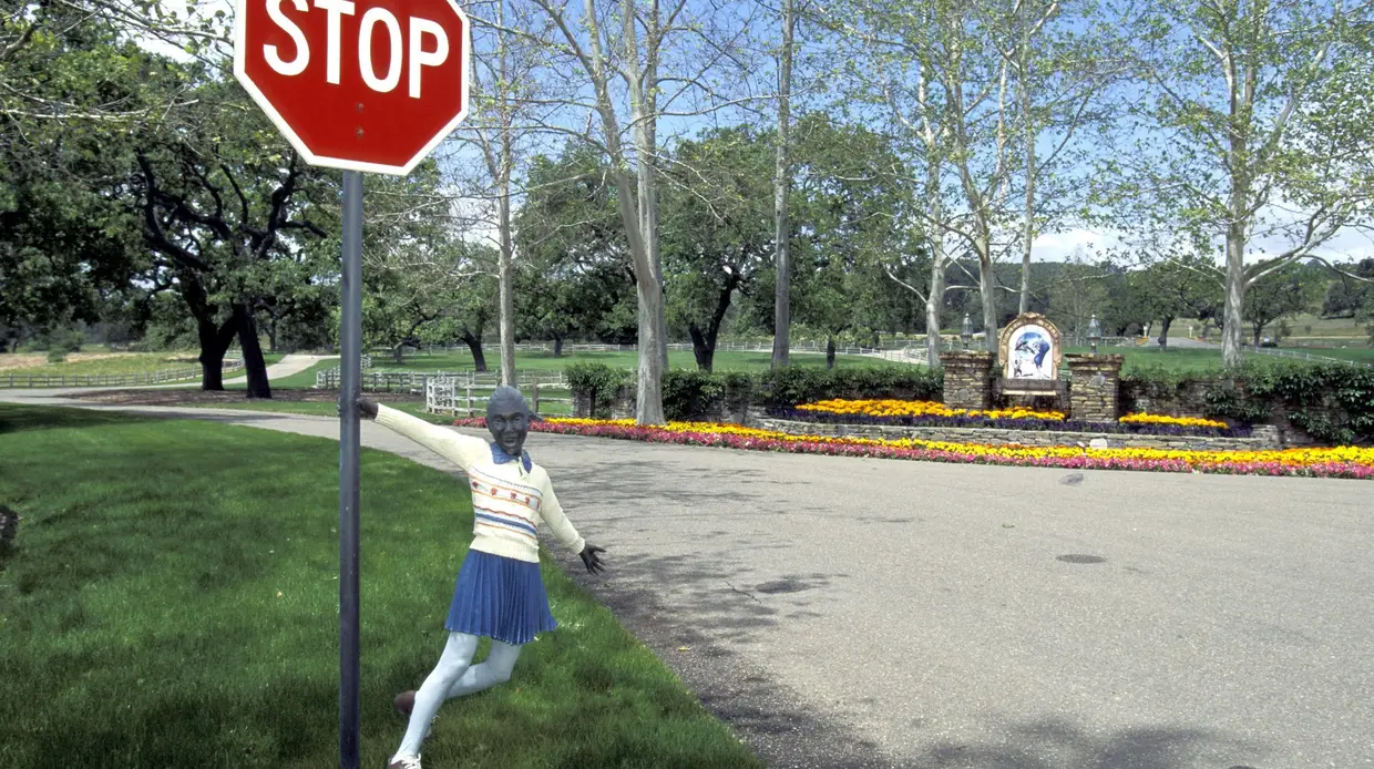 Rancho Neverland: estátua de colegial agarrada ao sinal de STOP