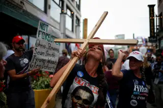 Uma apoiante de Trump beija uma cruz no exterior onde decorria a Convenção do Partido Republicano 