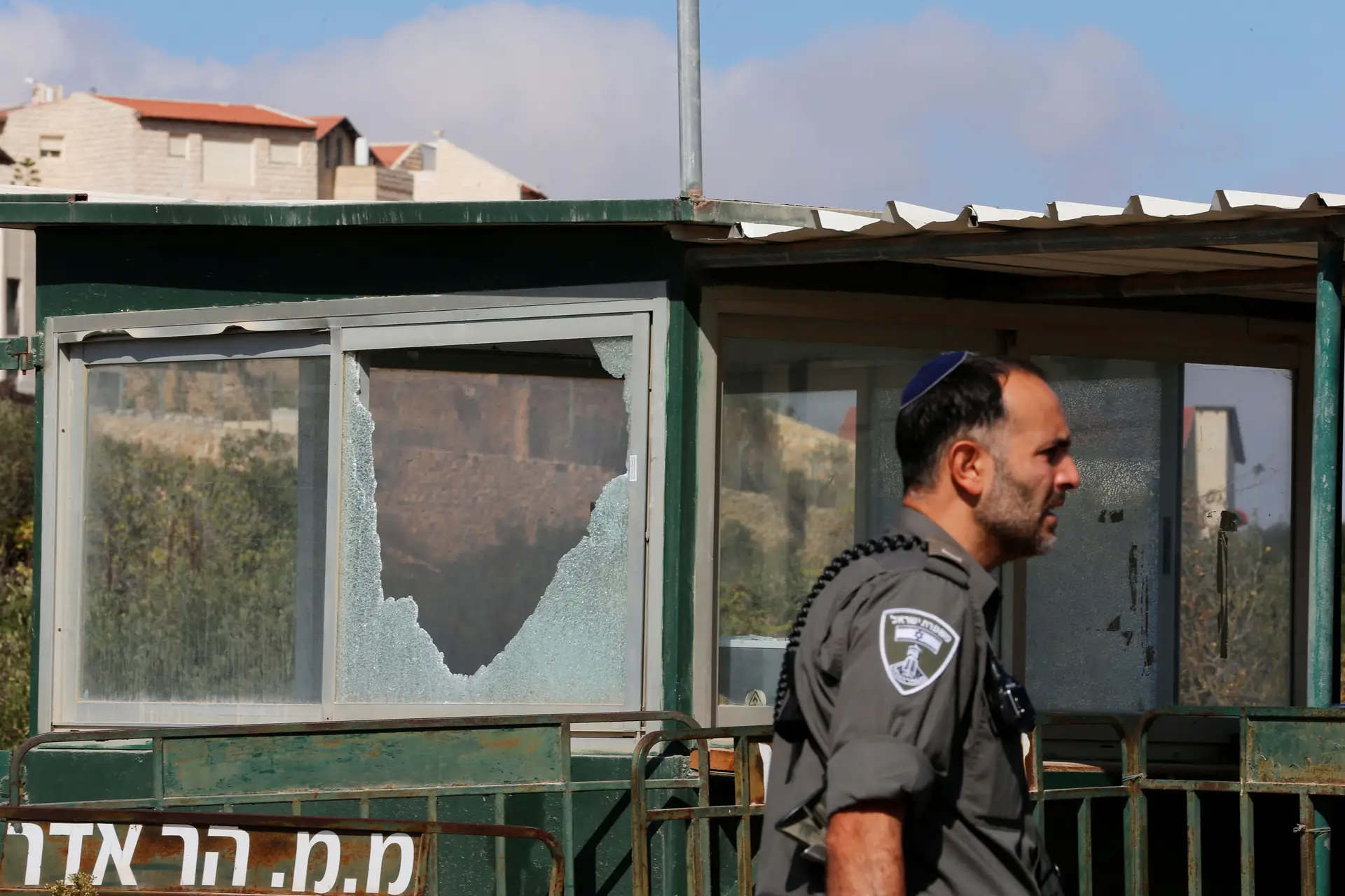 Polícia israelita junto ao posto de controlo, com vidros estilhaçados, à entrada do colonato de Har Adar, no território palestiniano ocupado da Cisjordânia