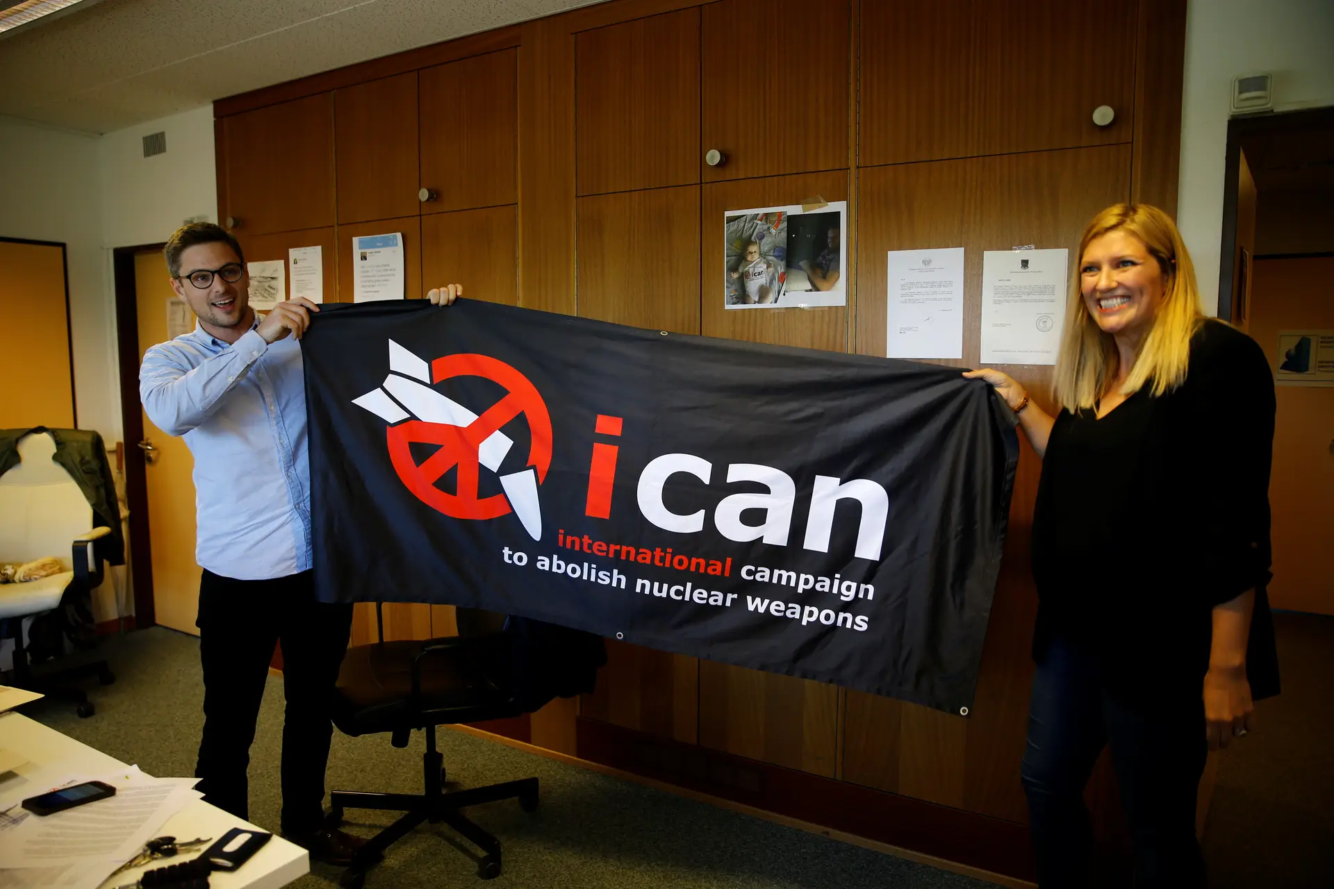 Beatrice Fihn, diretora executiva da Campanha Internacional para a Abolição das Armas Nucleares (ICAN), e Daniel Hogsta, coordenador, celebram o Nobel da Paz, na sede da organização, em Genebra, Suíça