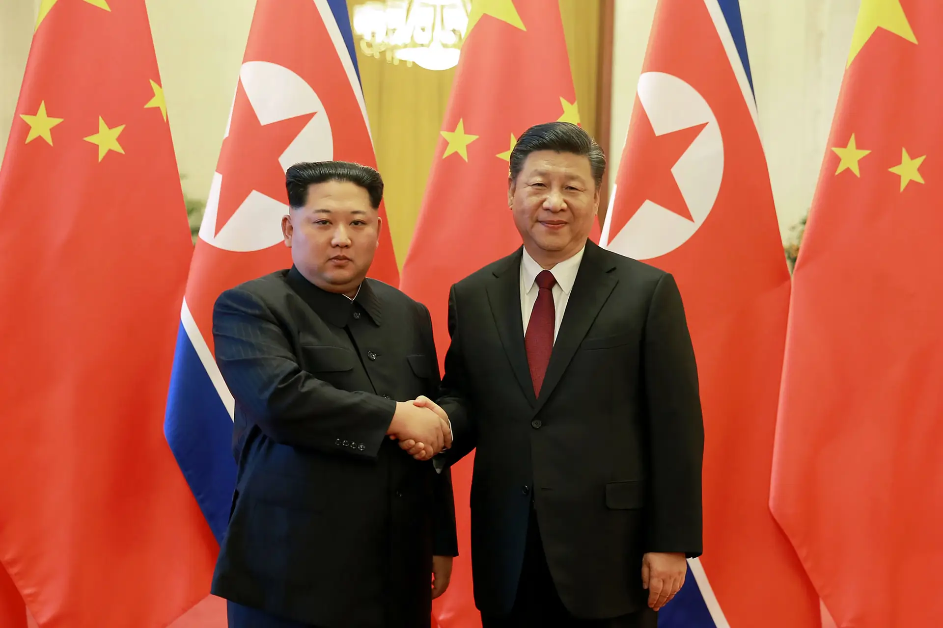 Kim Jong-un e Xi Jinping apertam as mãos em Pequim (27 de março de 2018)