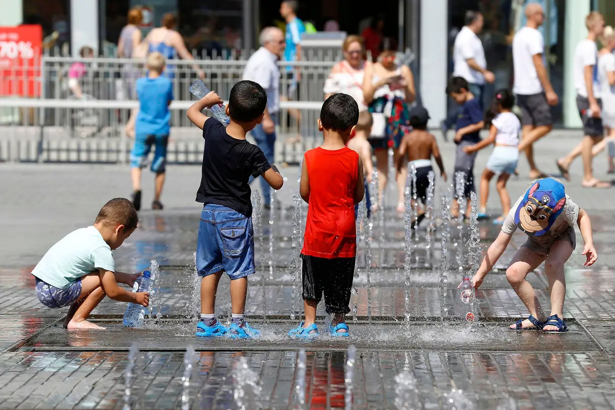 Brincadeiras diferentes para estas crianças belgas, junto aos chafarizes da Place La Monnaie, no centro de Bruxelas