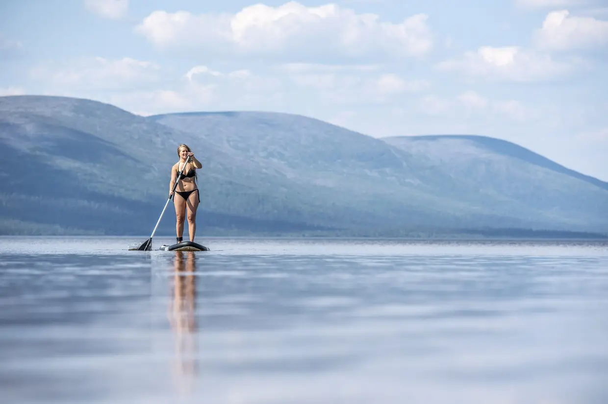 Uma mulher pratica remo em pé, no lago Pallasjarvi, na Lapónia, Finlândia