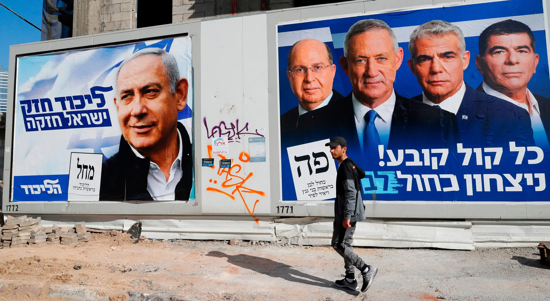 As sondagens prevêm uma disputa entre o Likud, do primeiro-ministro Benjamin Netanyahu (cartaz da esquerda), e a aliança Azul e Branco (poster da direita)