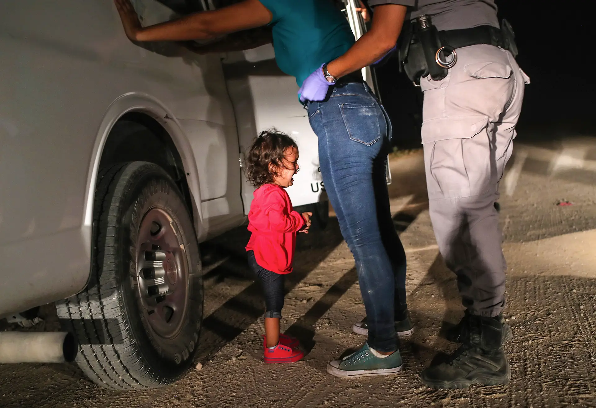 Uma criança espera na fronteira dos Estados Unidos com o México no pico da crise migratória de 2018. Muitas foram separadas dos seus pais e estão agora em lugares sem condições