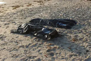 Sacos contendo corpos dos migrantes afogados ao largo da cidade costeira de Komas, Líbia