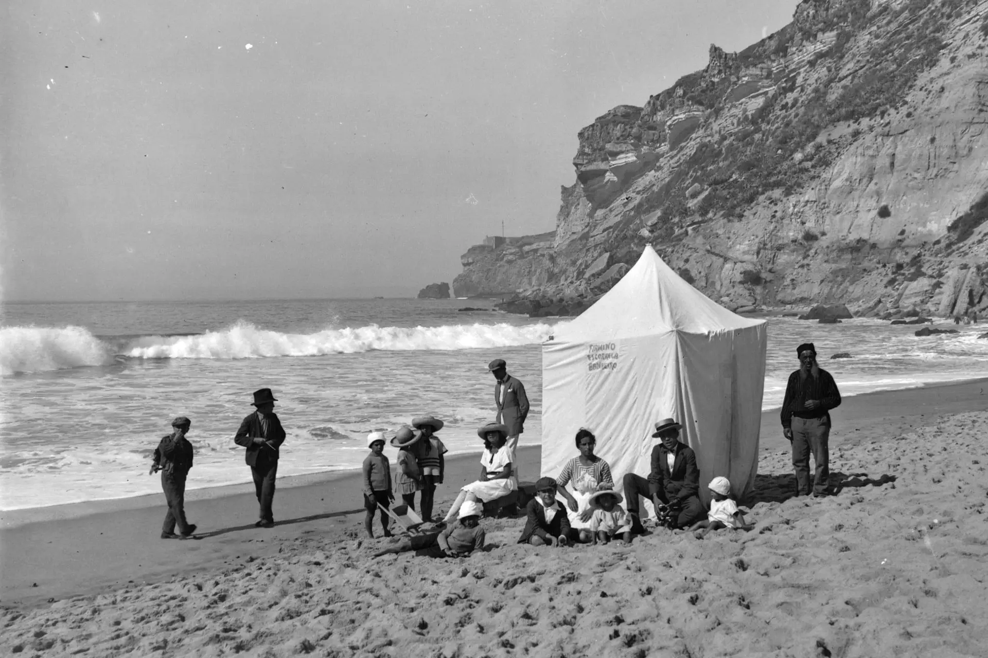 Praia da Nazaré. Família à beira-mar sentada ao lado de uma barraca