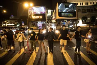Cidadãos de Hong Kong unem-se num cordão humano de 50 quilómetros em protesto contra a China. Veja as imagens