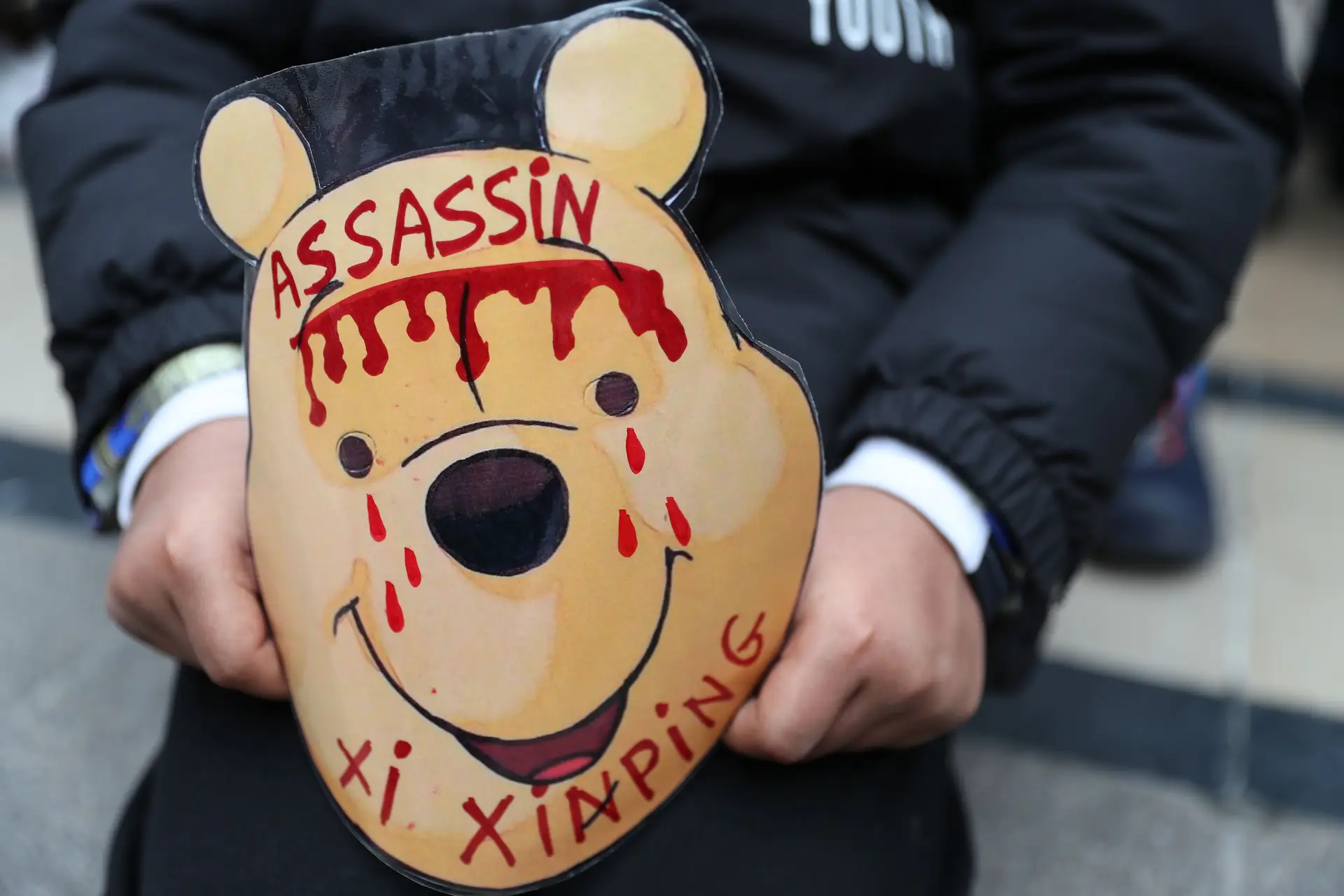 Em Paris, um manifestante segura uma máscara de Winnie the Pooh, frequentemente usada por críticos do regime chinês para ridicularizar o Presidente