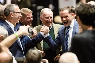 Tino Chrupalla, à direita, aperta a mão de um deputado da AfD, Karsten Hilse, sob o olhar do fundador do partido, Alexander Gauland
