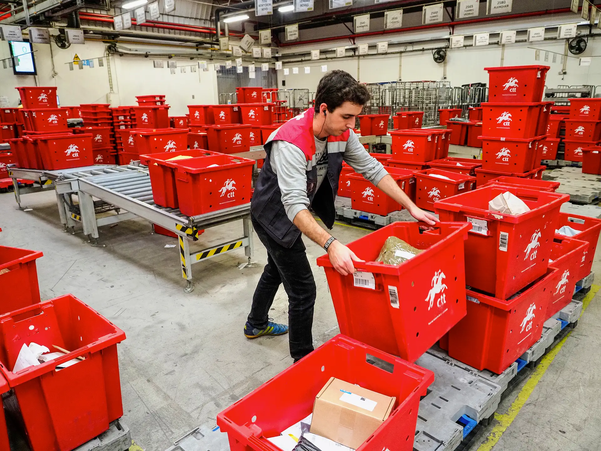 No centro de tratamento e distribuição de correio em Cabo Ruivo, Lisboa, as encomendas estão por todo o lado. Depois de um processo automático de separação e colocação em caixas, por código postal, são organizadas e empilhadas consoante o destino. Dali saem para todo o país