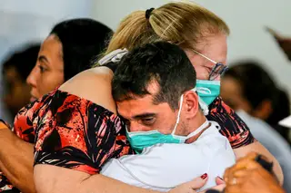 <span class="arranque"><span style="color:#d0b667">Conforto</span></span> Cidadãos brasileiros abraçam-se num hospital depois de informações que dão conta de casos de coronavírus no Brasil <span class="creditofoto">Adriano Machado/REUTERS</span>